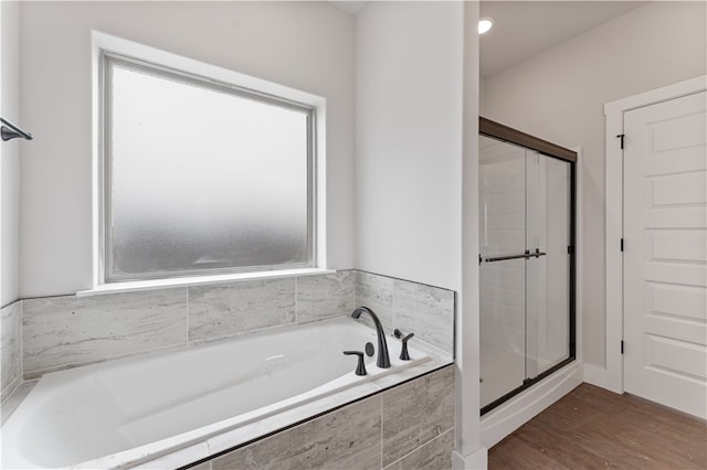 bathroom with independent shower and bath and wood-type flooring