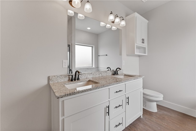 bathroom featuring toilet, hardwood / wood-style flooring, and vanity