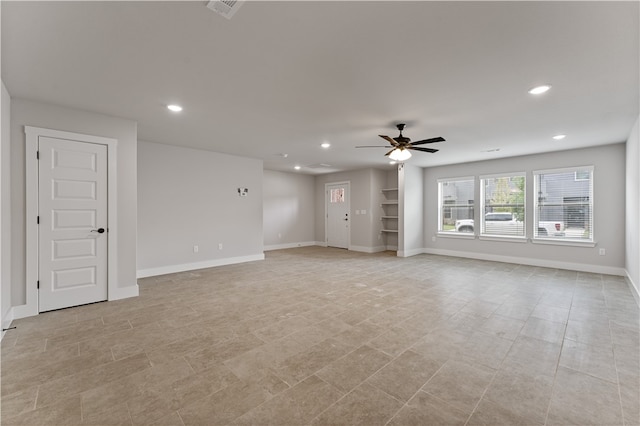 unfurnished living room featuring light tile patterned floors and ceiling fan