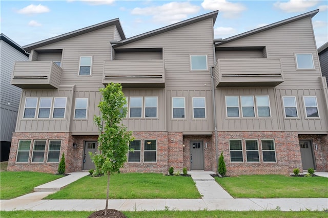 view of front of property featuring a balcony and a front yard