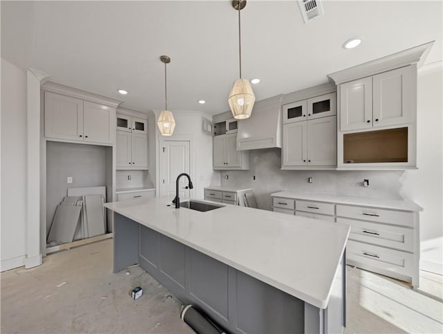 kitchen with a large island, sink, custom exhaust hood, and hanging light fixtures