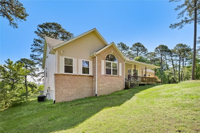 rear view of house with central AC and a lawn