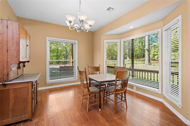 dining room featuring plenty of natural light, hardwood / wood-style flooring, and a notable chandelier