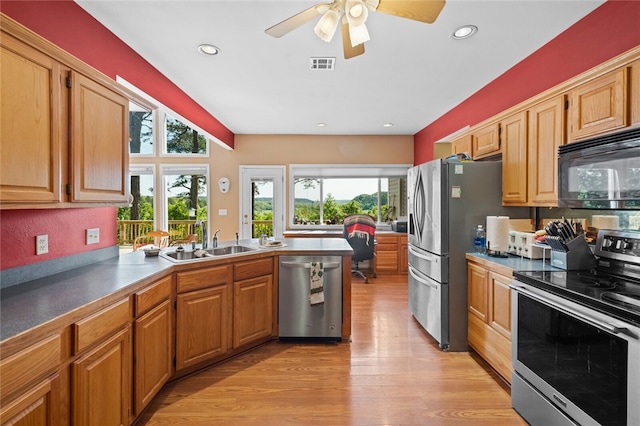 kitchen with appliances with stainless steel finishes, sink, ceiling fan, and light hardwood / wood-style flooring