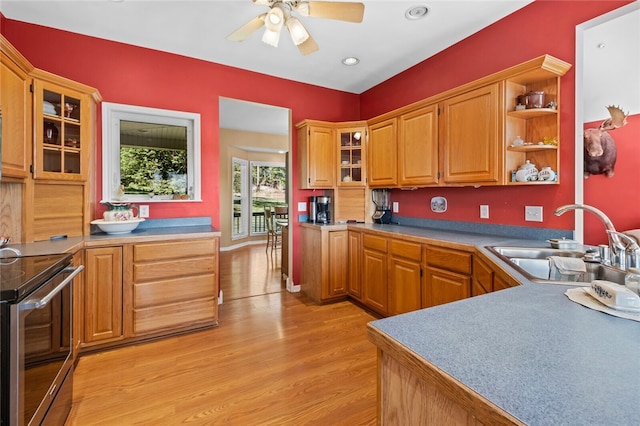 kitchen featuring stainless steel range with electric stovetop, sink, ceiling fan, and light wood-type flooring