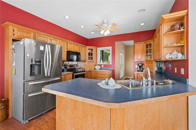 kitchen featuring stainless steel appliances, kitchen peninsula, hardwood / wood-style floors, sink, and ceiling fan