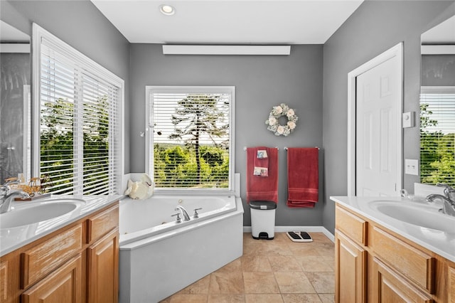 bathroom featuring a bath to relax in, tile flooring, a healthy amount of sunlight, and large vanity