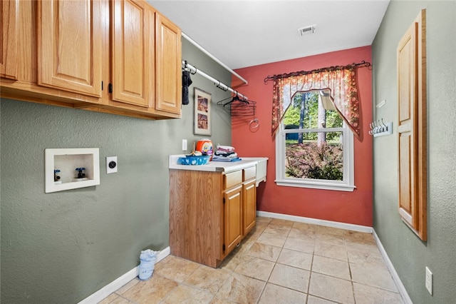 washroom with washer hookup, electric dryer hookup, cabinets, and light tile floors