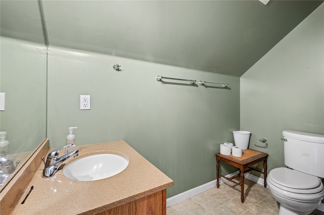 bathroom with tile flooring, toilet, and vanity