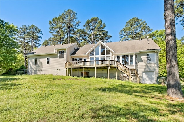 rear view of house with a garage, a wooden deck, and a yard