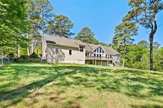 back of house featuring a deck and a lawn