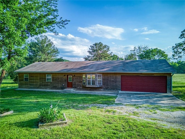 ranch-style house featuring a garage and a front lawn