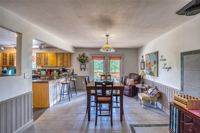 dining space featuring wooden walls and french doors