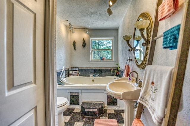 bathroom featuring a textured ceiling, toilet, and a bathing tub