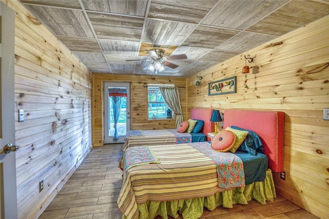 bedroom with wooden ceiling, ceiling fan, wooden walls, and hardwood / wood-style flooring