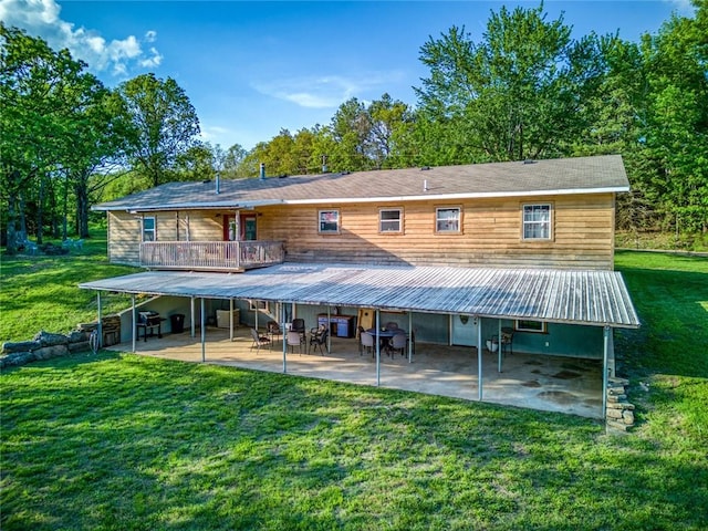 rear view of house featuring a balcony, a yard, and a patio