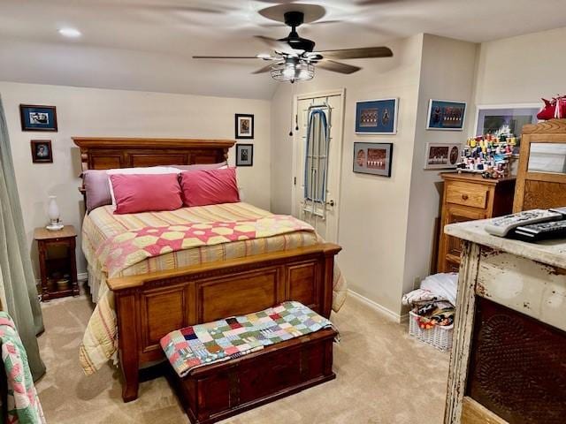 bedroom featuring baseboards, light colored carpet, and ceiling fan