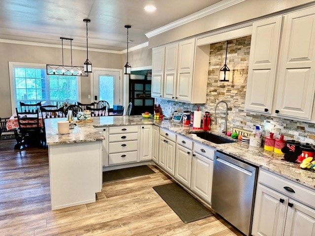 kitchen featuring kitchen peninsula, hanging light fixtures, crown molding, stainless steel dishwasher, and sink