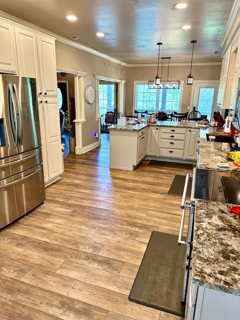 kitchen with light hardwood / wood-style floors, hanging light fixtures, ornamental molding, white cabinetry, and stainless steel refrigerator with ice dispenser