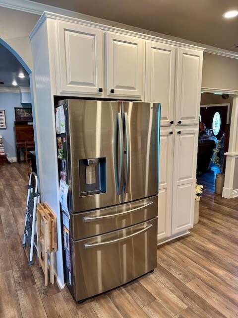 kitchen with crown molding, stainless steel fridge with ice dispenser, white cabinets, and hardwood / wood-style flooring