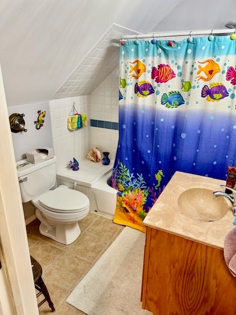 full bathroom featuring vaulted ceiling, toilet, tile floors, vanity, and shower / bath combo