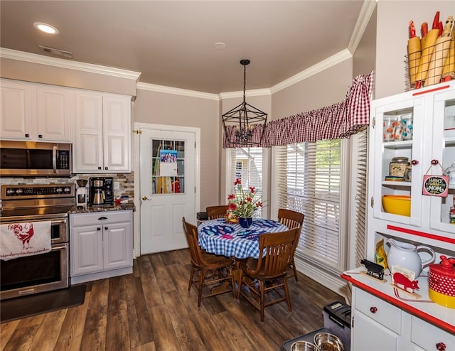 dining space featuring dark hardwood / wood-style floors, ornamental molding, and an inviting chandelier