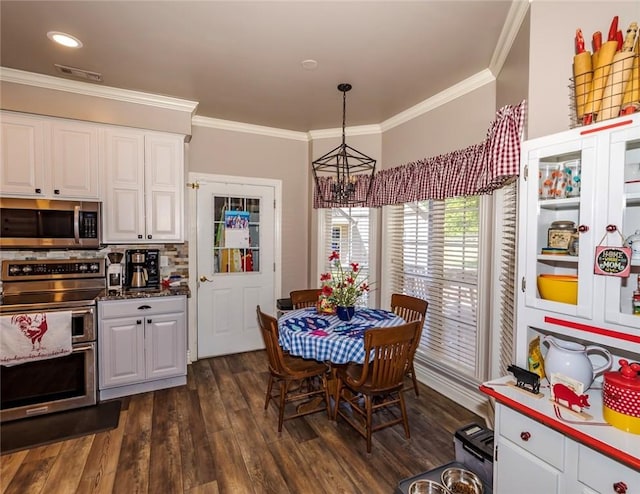 dining room featuring dark wood-style floors, visible vents, a chandelier, and crown molding