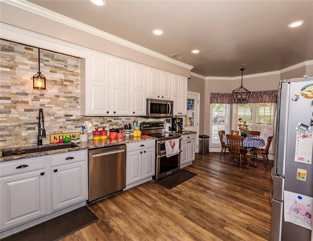 kitchen with decorative light fixtures, dark hardwood / wood-style flooring, sink, white cabinetry, and appliances with stainless steel finishes