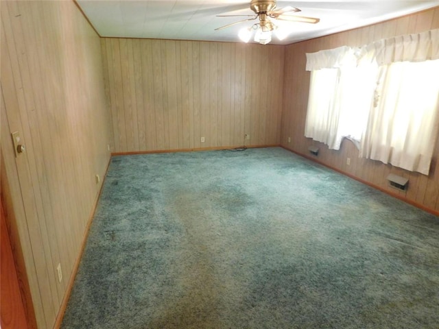 spare room featuring light colored carpet, ceiling fan, and wooden walls