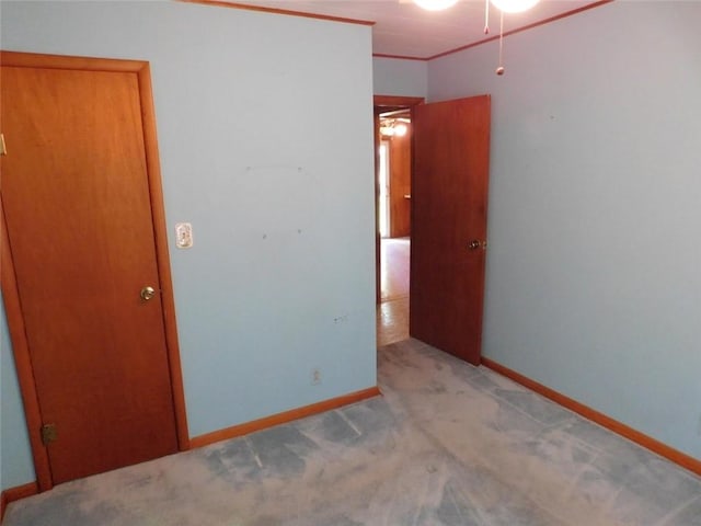 unfurnished bedroom featuring crown molding and light colored carpet