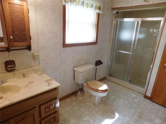 bathroom with toilet, an enclosed shower, and vanity