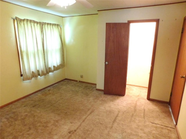 spare room with light colored carpet and ceiling fan