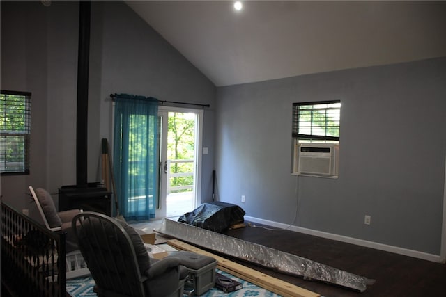 living room featuring high vaulted ceiling, a wood stove, plenty of natural light, and hardwood / wood-style floors