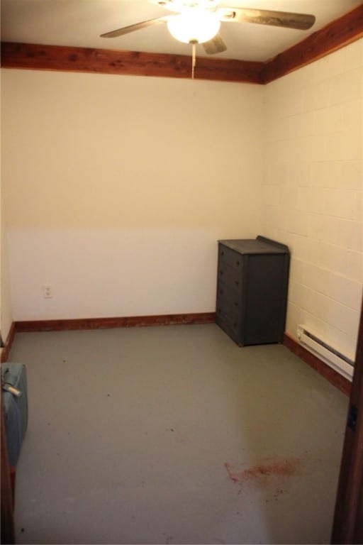 empty room with ceiling fan, a baseboard radiator, and concrete flooring