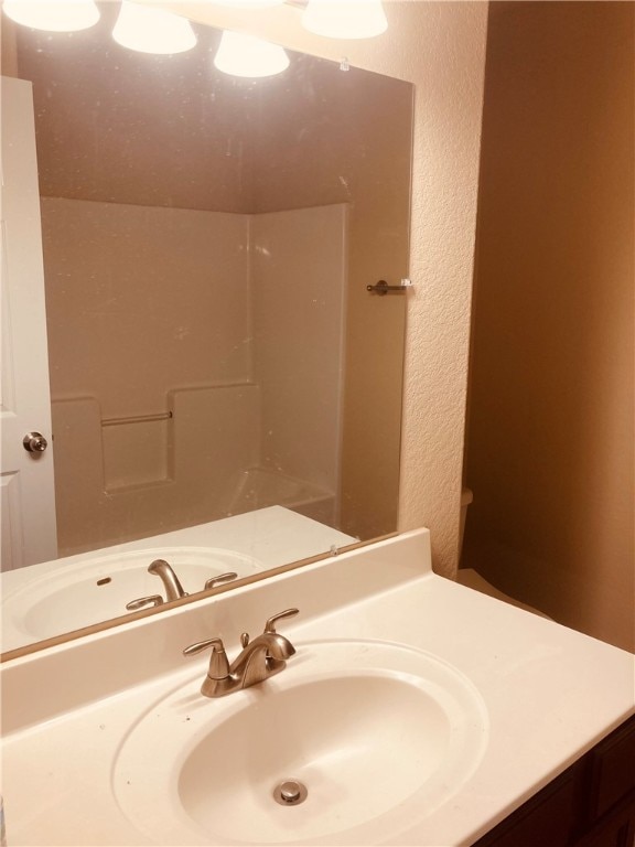 bathroom with vanity and a textured wall