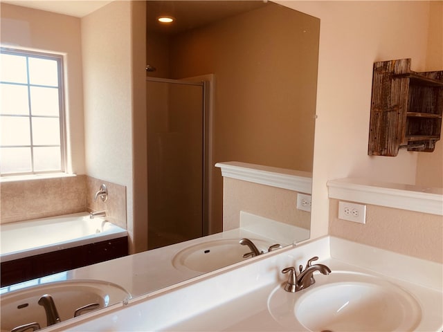 bathroom featuring a wealth of natural light, a garden tub, a stall shower, and vanity