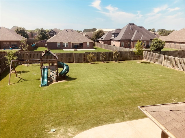 view of yard featuring a residential view, a playground, and a fenced backyard