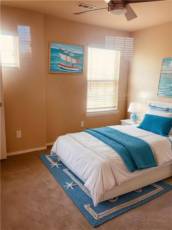 carpeted bedroom with a ceiling fan, baseboards, and visible vents