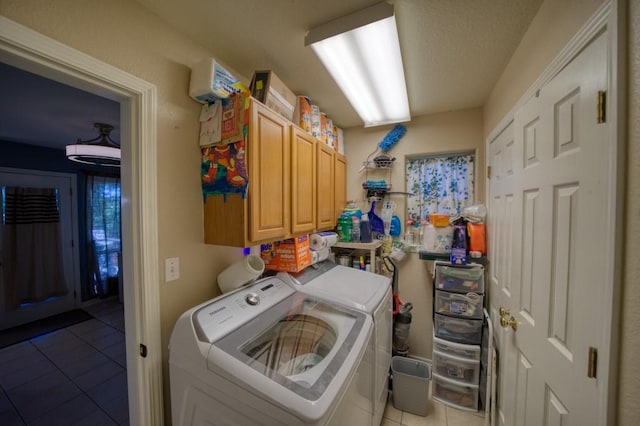 clothes washing area with cabinets, independent washer and dryer, and light tile patterned floors