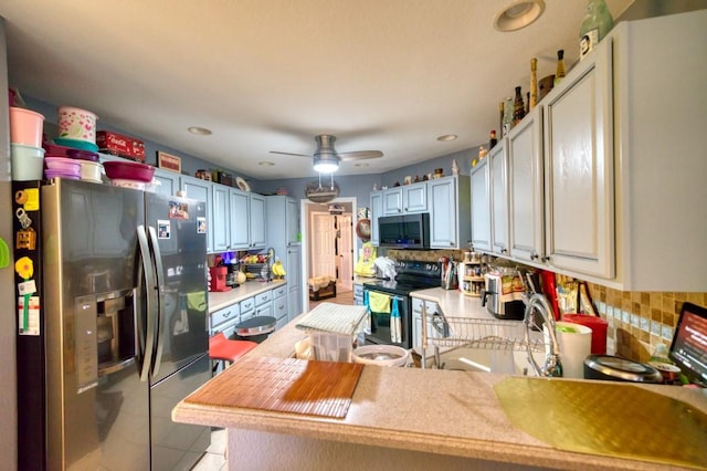 kitchen featuring kitchen peninsula, appliances with stainless steel finishes, tasteful backsplash, ceiling fan, and light tile patterned flooring