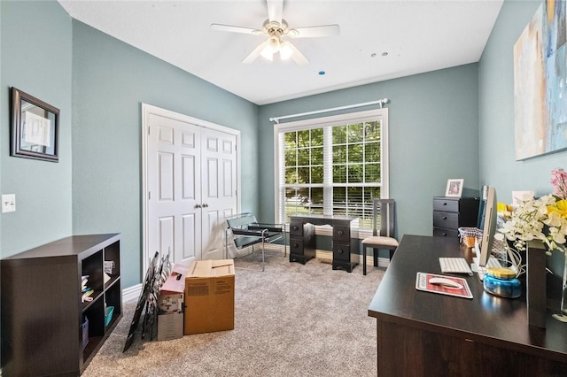 carpeted home office featuring ceiling fan