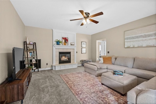 living room with a tiled fireplace, carpet floors, and ceiling fan