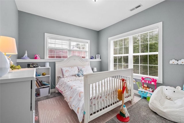 carpeted bedroom featuring multiple windows