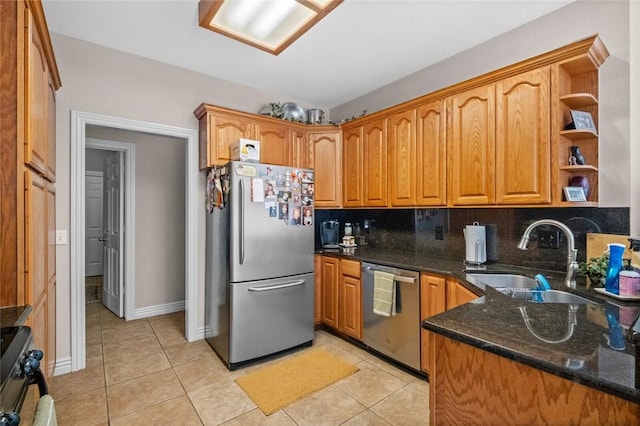 kitchen featuring light tile patterned flooring, sink, dark stone countertops, appliances with stainless steel finishes, and decorative backsplash