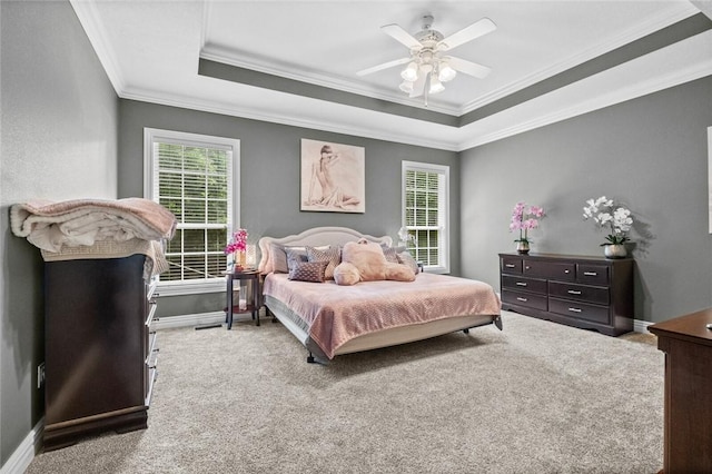 carpeted bedroom featuring ceiling fan, a raised ceiling, and multiple windows