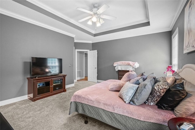 carpeted bedroom with a raised ceiling, crown molding, and ceiling fan