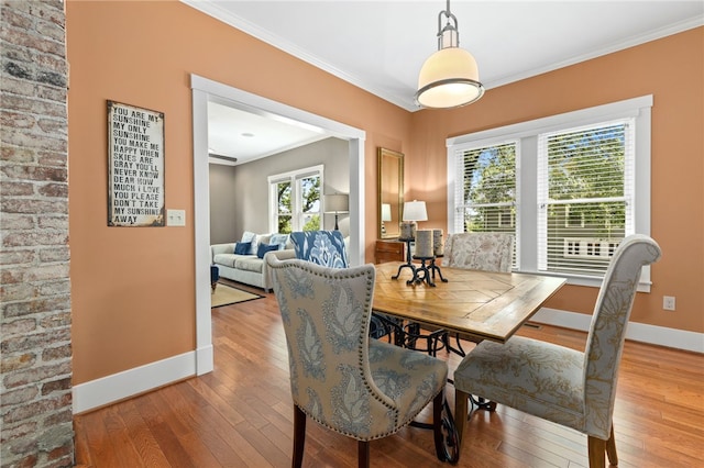 dining space with hardwood / wood-style flooring and ornamental molding