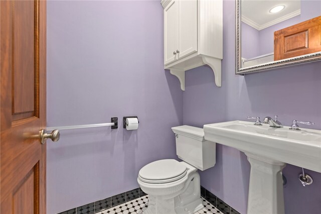 bathroom featuring toilet, ornamental molding, and sink