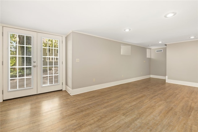 unfurnished room featuring crown molding, french doors, and light wood-type flooring