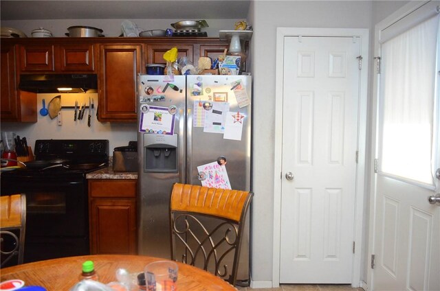 kitchen with black / electric stove and stainless steel fridge